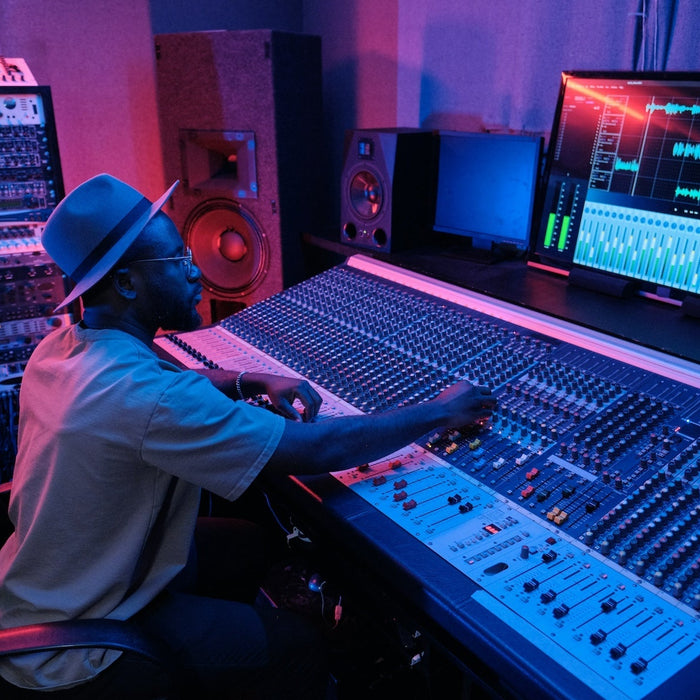 A producer chopping a drum break waveform at their workstation