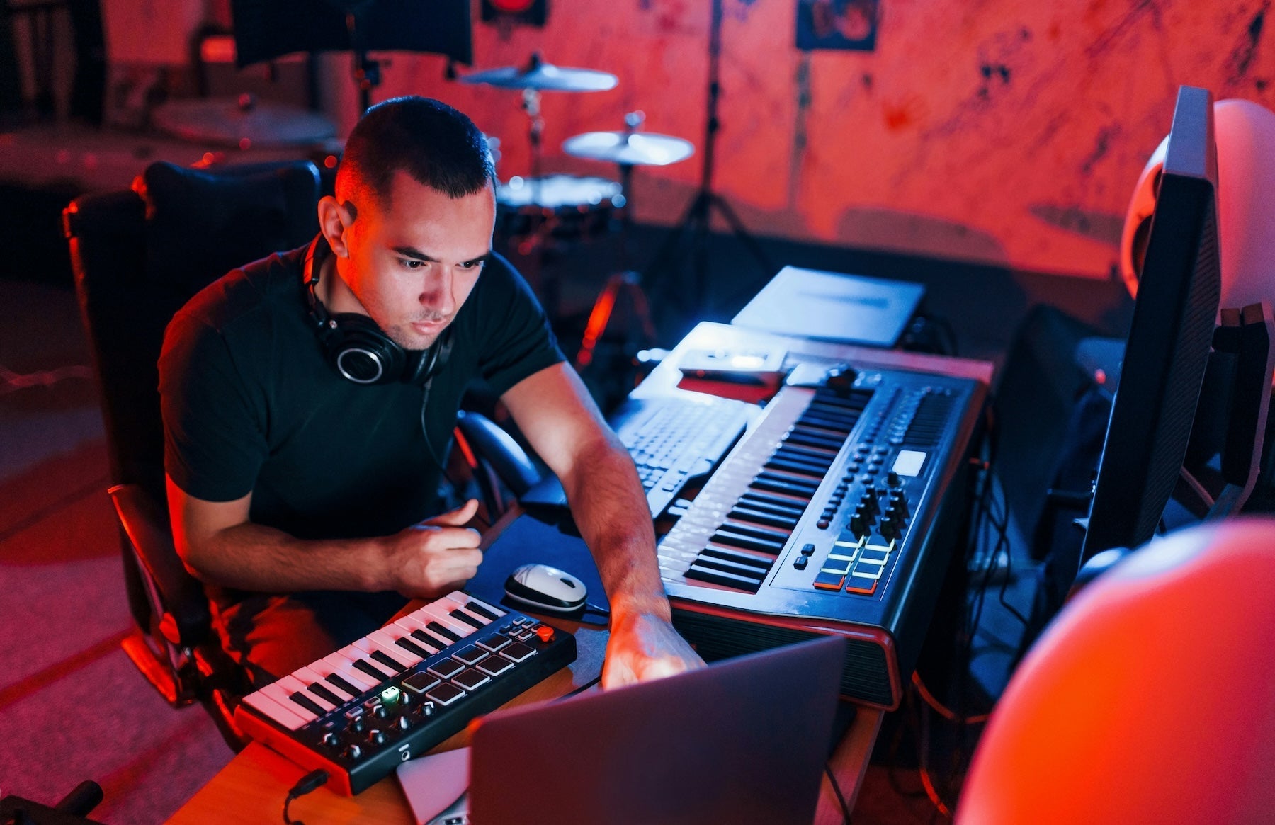 A dubstep producer working on a 140 BPM halftime track at their studio desk