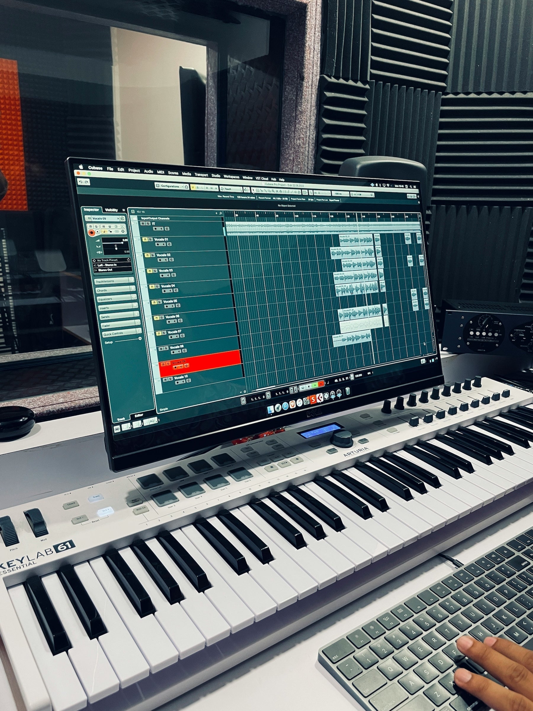 Producer auditioning samples at a desk with monitors and headphones
