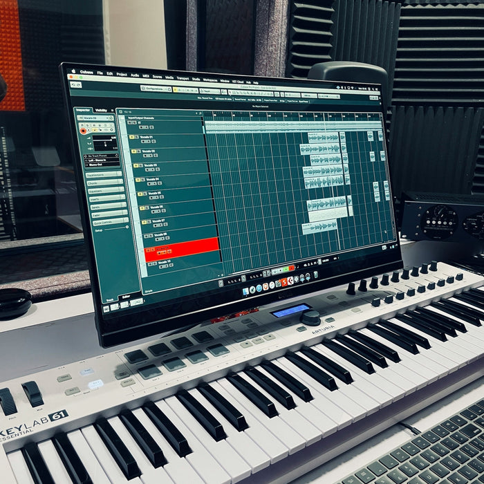 Producer auditioning samples at a desk with monitors and headphones