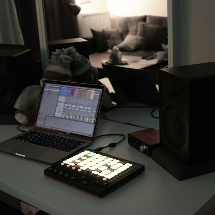 Producer adjusting EQ and compression plugins on the master bus in a DAW