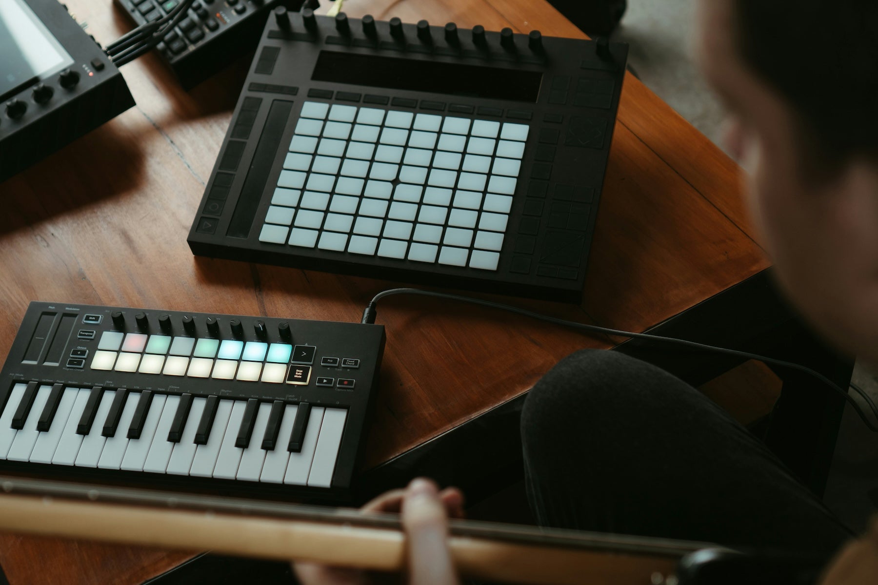 Producer self-mastering a track at a home studio desk with monitors and a laptop
