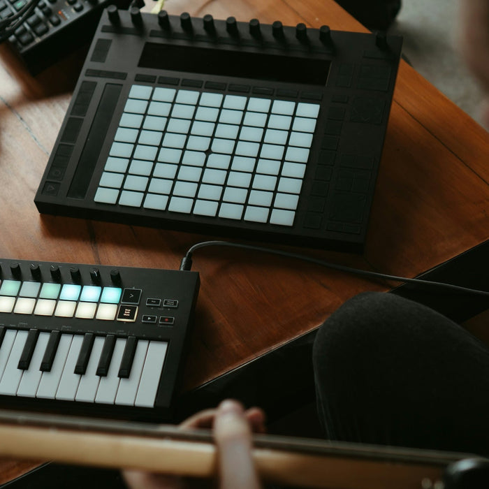 Producer self-mastering a track at a home studio desk with monitors and a laptop