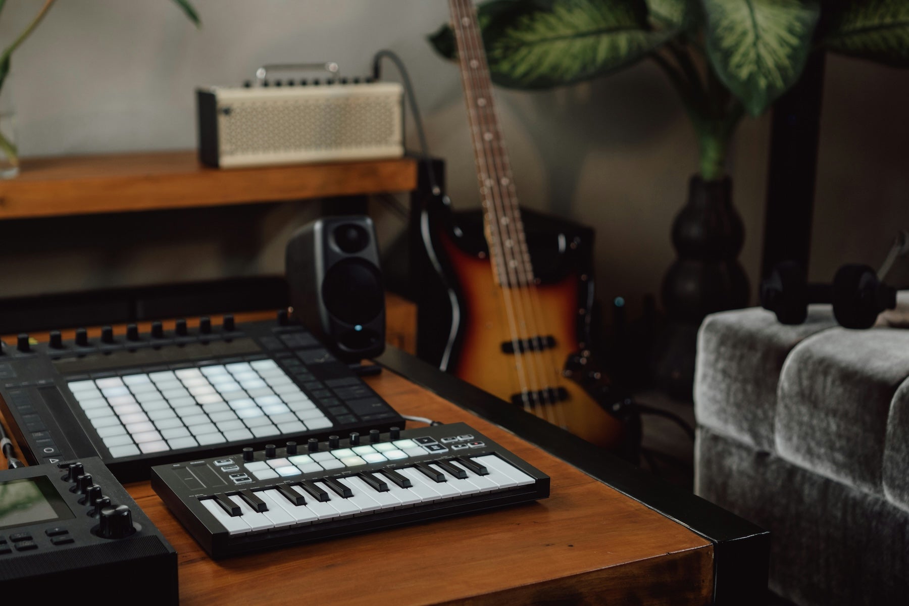 Producer clicking notes into a DAW piano roll on a desktop monitor