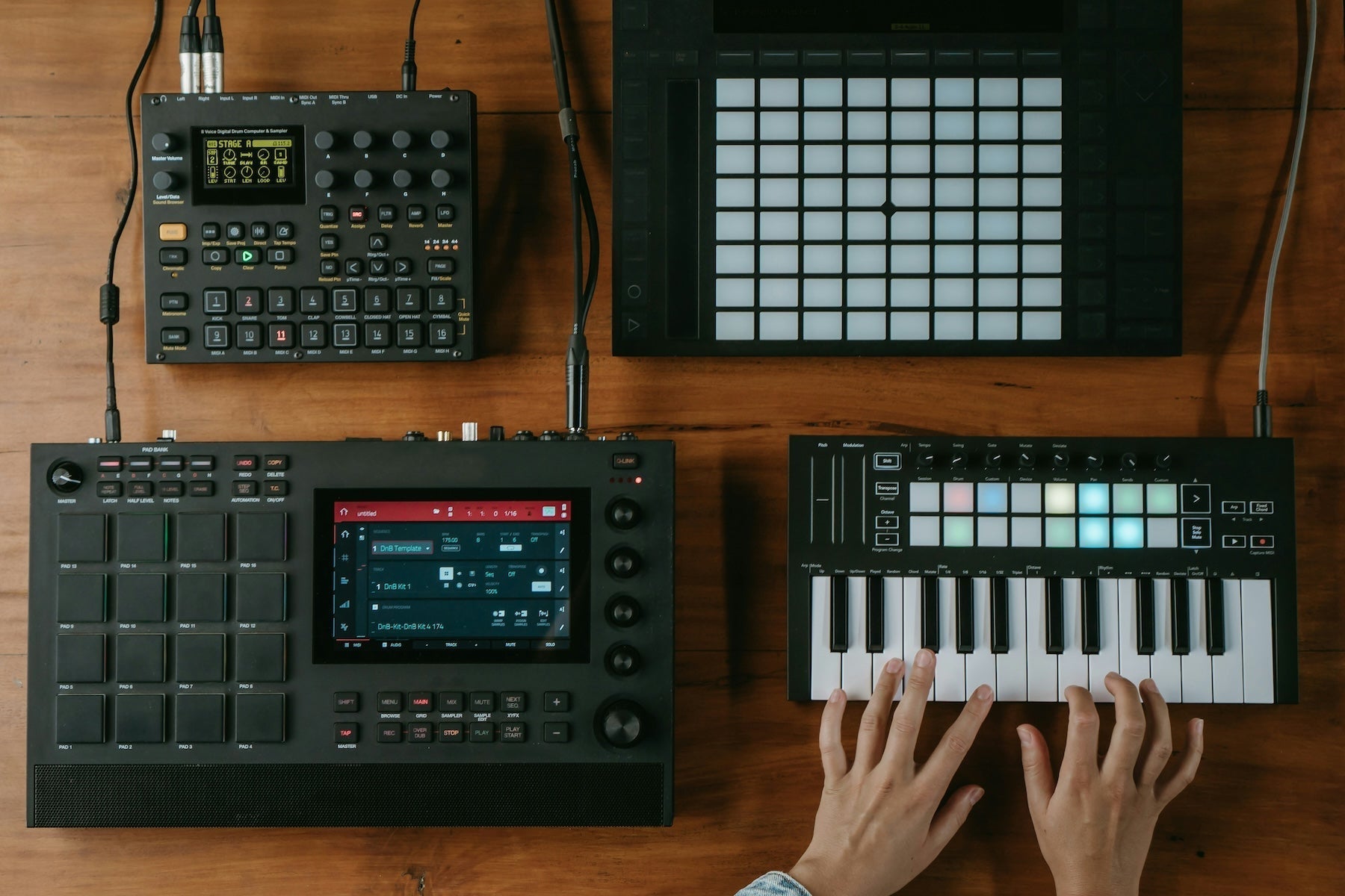 Producer auditioning melodic ideas on a small MIDI keyboard next to a laptop
