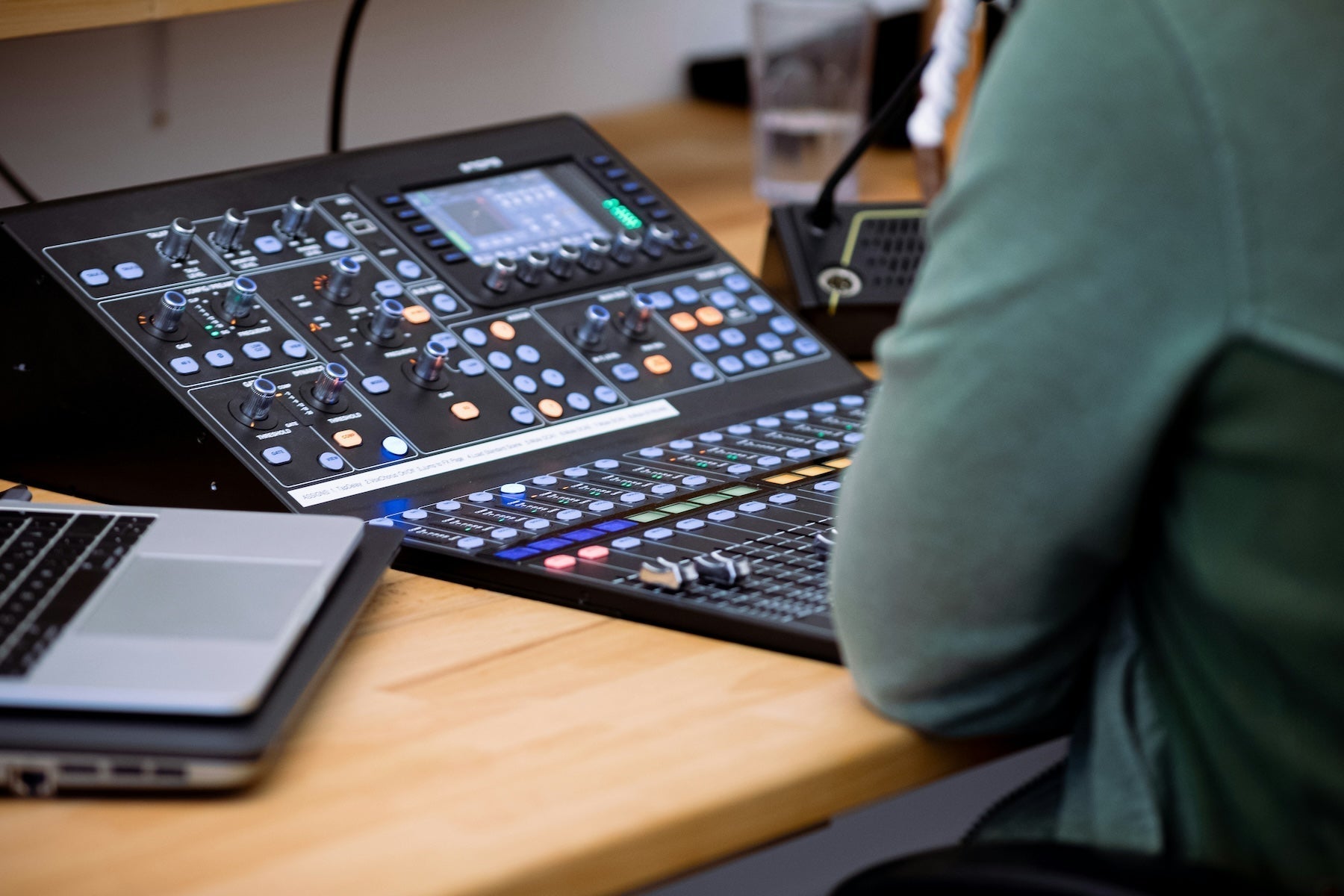 Producer working out chord voicings at a weighted MIDI controller next to studio monitors