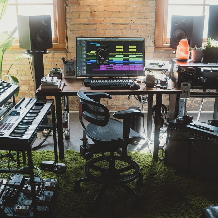 Producer programming a bassline in a DAW piano roll alongside drum channels